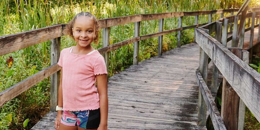 girl standing on bridge in wetlands