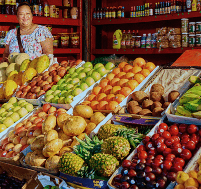 woman surrounded by fruit at market stand