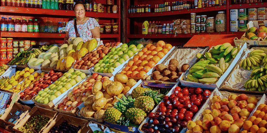 woman surrounded by fruit at market stand