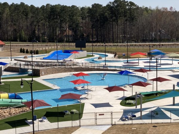 Shows portion of Spivey Splash water park including wave ride, cabana covered seating, pool and lifeguard stations.