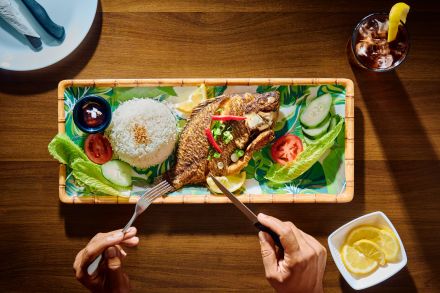 fish on a plate and person with fork and knife