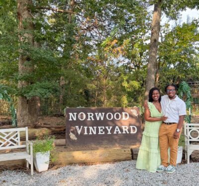 couple outside next to sign